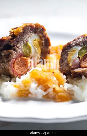 beef roulade filled with egg, sausage, bacon and prickle served with rice Stock Photo
