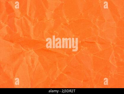Wrinkled sheet of orange paper. Textured backdrop. Stock Photo