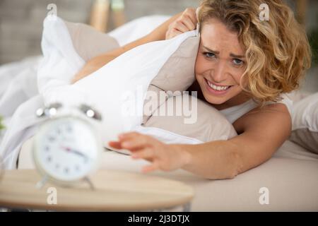 young woman getting stressed about waking up too early Stock Photo