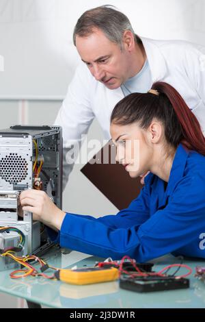 teacher showing student on whiteboard how to fix a computer Stock Photo