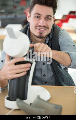 professional young worker fixing coffee machine Stock Photo