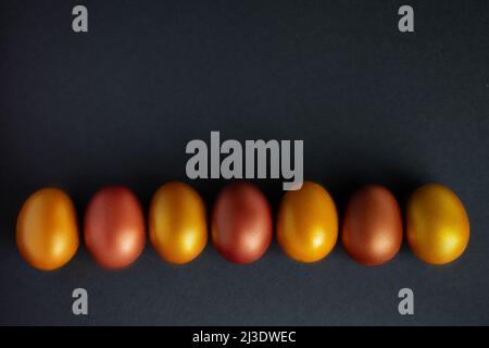 Luxurious golden Easter eggs. Festive decor on black background. Place for text. Stock Photo