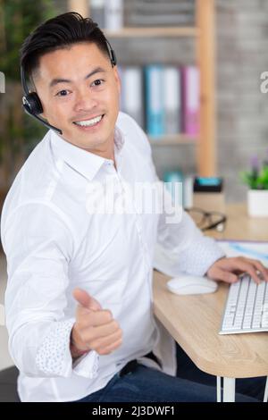 young smiling male call centre operator with a headset Stock Photo