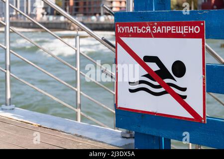 No swimming sign with Russian text mounted on a pier Stock Photo