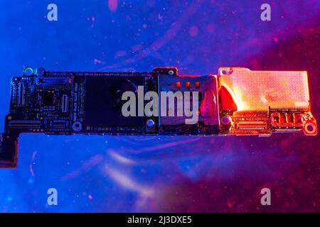 The main board from the phone, in the water with blue and red lights in the water Stock Photo