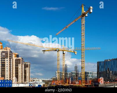 Construction crane. Construction site. Tower cranes against the sky. House under construction. Stock Photo
