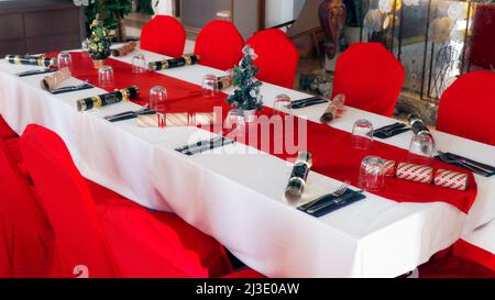 christmas concept festive dining table set up with red and white cloths Stock Photo
