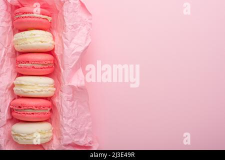 Macaroons in a box on a light pink background, flatlays, with an empty space for writing on a postcard or congratulations Stock Photo