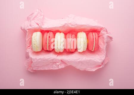 Macaroons in a box on a light pink background, flatlays Stock Photo