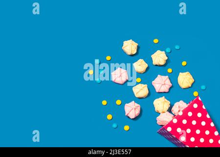 Meringues in a pink bucket and on a blue background with copy space Stock Photo