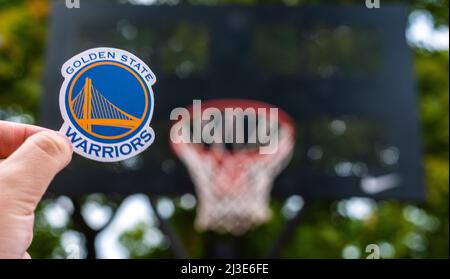 September 15, 2021, San Francisco, USA, A man holds the emblem of the basketball club Golden State Warriors on the sports ground. Stock Photo