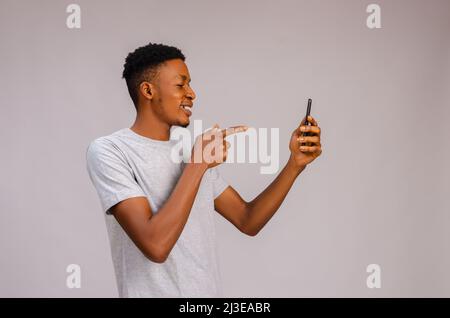guy smiling and pointing to his phone Stock Photo