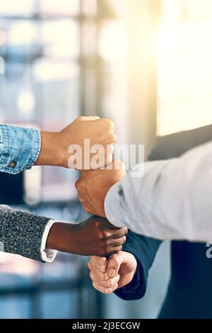 Supporting one another. Cropped shot of a group of unrecognizable businesspeople stacking fists. Stock Photo