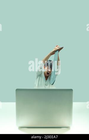 To the fight! Infernal machine I will prevail! Woman fights with her laptop with a medieval sword. Concept of frustration with computers and technolog Stock Photo