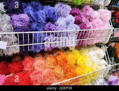 multicolored skeins of terry threads and yarn on display in needlework store Stock Photo