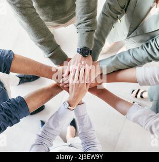 Concentrate all your thoughts upon the work in hand. Shot of a group of unrecognizable businesspeople stacking their hands at work. Stock Photo