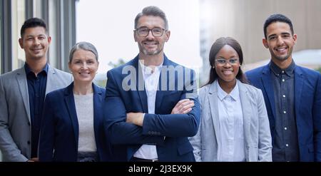 Were the team you need. Cropped portrait of a group of corporate businesspeople standing outside with their arms folded. Stock Photo