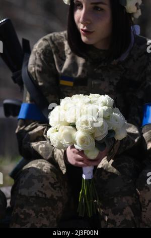 Portrait of a Ukrainian military woman with a machine gun in the hands ...