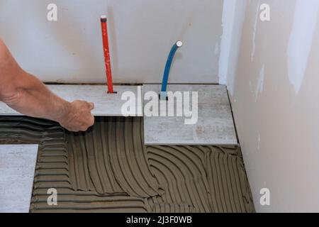 Working tiles lay a tile on the floor Stock Photo