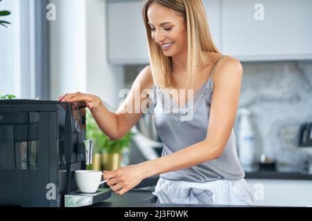 Nice woman making coffee in the kitchen Stock Photo