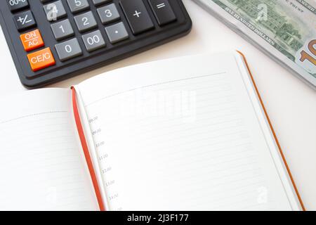 Calculator notepad and stack of money on white background. Stock Photo