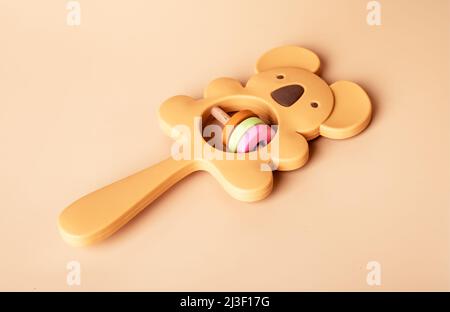 Wooden eco beanbag rattle and teether in koala shape. Baby accessory on beige background. Organic toy for newborn. High quality photo Stock Photo