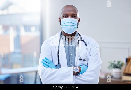 The only thing I want to spread is good medical advice. Shot of a male doctor wearing a surgical mask and gloves. Stock Photo