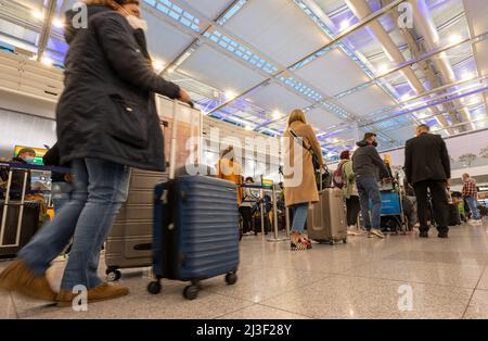 Munich, Germany. 08th Apr, 2022. Airline passengers stand at a check-in counter at Munich Airport. Credit: Peter Kneffel/dpa/Alamy Live News Stock Photo