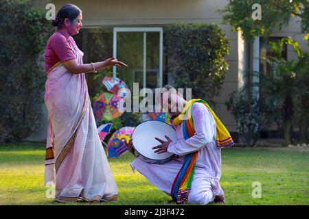 Happy middle aged couple enjoying Holi festival by playing drum and dancing Stock Photo
