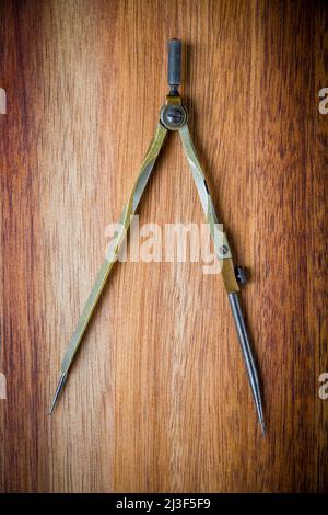 Old vintage pair of compasses on a wooden table background Stock Photo