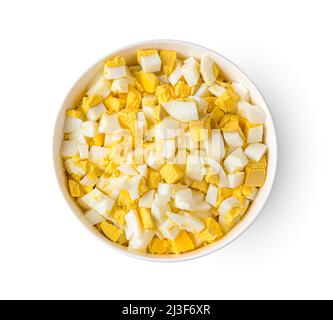 Boiled eggs diced in a bowl isolated on a white background. Top view Stock Photo