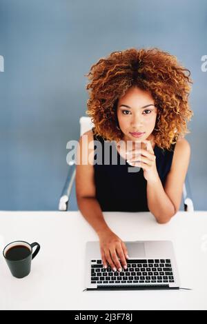 On the cutting edge of online marketing. Portrait of a young businesswoman working on a laptop at her desk. Stock Photo