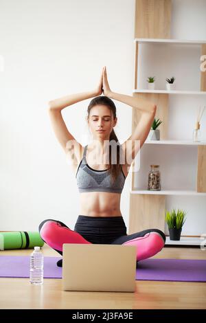 Premium Photo  Attractive young woman doing yoga stretching yoga online at  home.