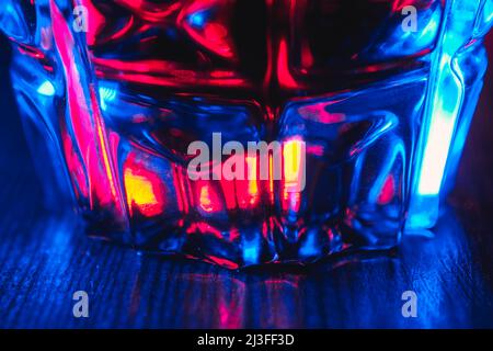 Close up tincture of red color in a crystal glass in neon lighting Stock Photo