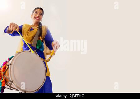 Portrait of Sikh woman playing drum during Baisakhi celebration Stock Photo