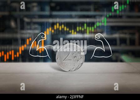 Coin of Russian ruble with hands and muscles concept. Strengthening and growth of the value of the Russian currency chart with oil refinery pipes in t Stock Photo