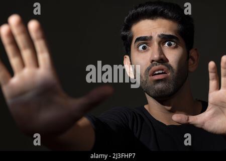 Portrait of a scared young man looking with wide eyes Stock Photo