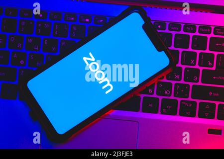Zoom app logo on the screen smartphone closeup. Zoom Video Communications is a company that provides remote conferencing services. Stock Photo