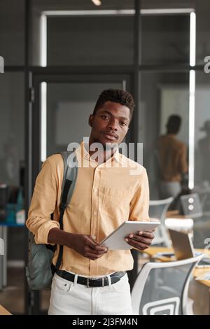Portrait of serious young black student with satchel using tablet in modern coworking space Stock Photo