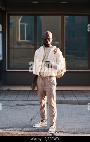 Serious young black man in sunglasses wearing fashionable street outfit using gps navigation on phone in big city Stock Photo