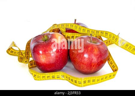 close up of several red apples isolated on a white background with a measuring tape Stock Photo