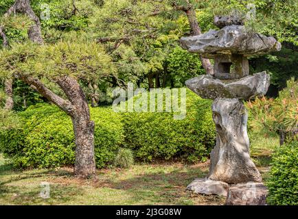 Stone lantern at the Japanese Garden at Shinjuku Gyoen National Garden, Tokyo, Japan Stock Photo