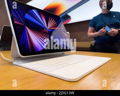 Paris, France - Ap 7, 2022: New Apple Computers iPad Pro tablet on the iconic Magic Keyboard with Genius worker in background Stock Photo