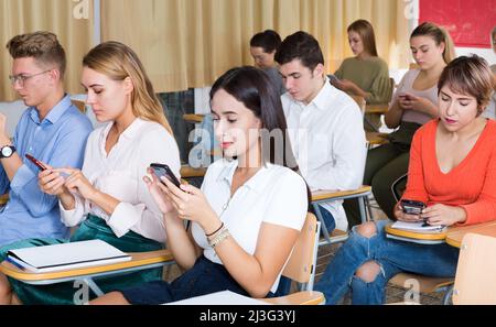 Students using smartphones on lecture Stock Photo