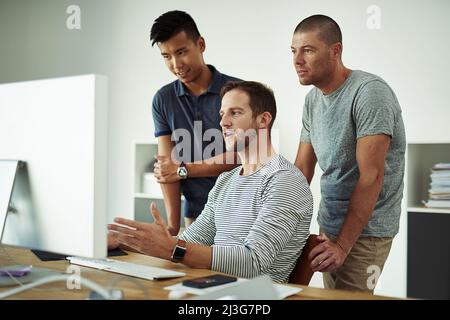 Brainstorming their way to success. Cropped shot of three designers working together on a project in an office. Stock Photo
