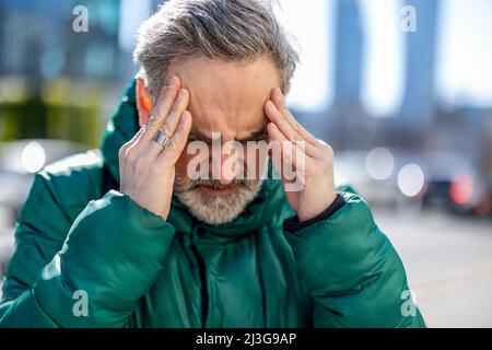 Man standing with hands on head, having a headache Stock Photo
