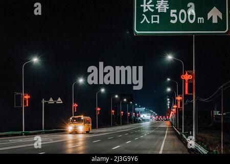 (220408) -- CHANGCHUN, April 8, 2022 (Xinhua) -- A school bus transporting supportive team members is seen on its way to Changchun, northeast China's Jilin Province, April 3, 2022. Some 5,000 supportive staff from Meihekou City who are aiding Changchun, one of the hardest-hit cities in China amid the latest virus resurgence, commute between the two cities every day in order to lessen boarding and lodging burdens on Changchun. The supportive team members, including medics, government officials and police officers, start off early morning and get back in late night, both by taking ferry buses. T Stock Photo