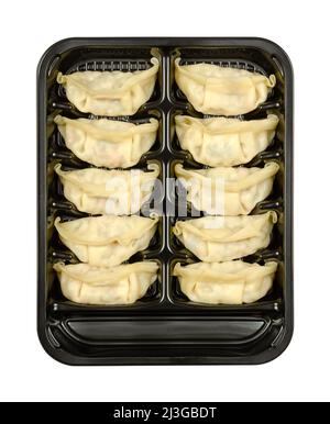 Gyoza, Japanese dumplings, in a black plastic tray. Uncooked, filled dumplings, ready to boil or fry. Filling, wrapped in thin batter. Stock Photo