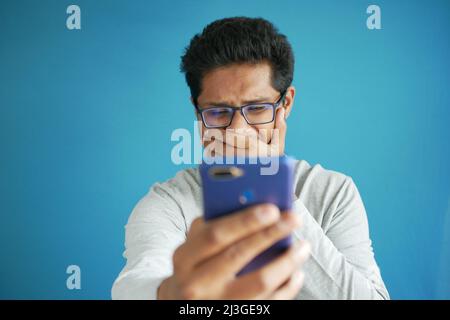 sad young man using smart phone indoor  Stock Photo