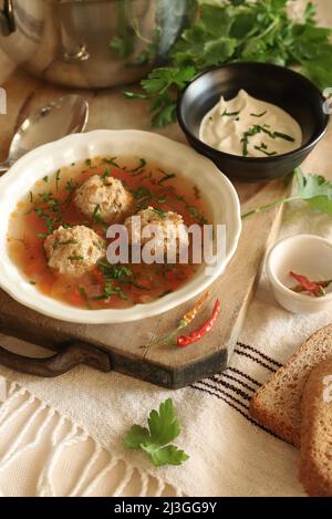 Soup with meatballs and vegetables isolated on the table. Romanian cuisine. Copy space. Directly above. Stock Photo